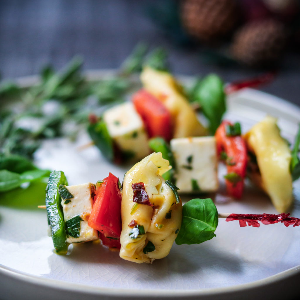 Festive Marinated Tortellini Skewers Close Up | giveitsomethyme.com – an easy recipe of tortellini, fresh mozzarella and bell peppers marinated in a zesty lemon vinaigrette! #tortelliniskewers #tortelliniskewersappetizers #marinatedtortelliniskewers #pastaappetizers #pastaappetizerseasy #pastaappetizerspartiesfood #christmasappetizers #christmasappetizerseasy #holidayappetizers #holidayappetizerseasy #giveitsomethyme