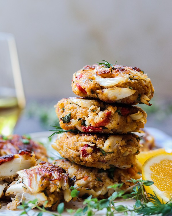 Jumbo Lump Crab Cakes Stacked – succulent high lump crab-to-breading ratio cakes served with a silky, luscious citrusy sauce. #appetizers #springrecipe #summerrecipe #lightdinners #lightdinnersforsummer #crabcakes #crabcakesrecipe #meyerlemon #chardonnaysauce #winesauce #giveitsomethyme | giveitsomethyme.com