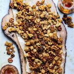 spicy garlic ranch chex mix served over large rustic wooden board over brown parchment