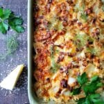 Baked potato gratin with crispy edges sprinkled with parmesan cheese.